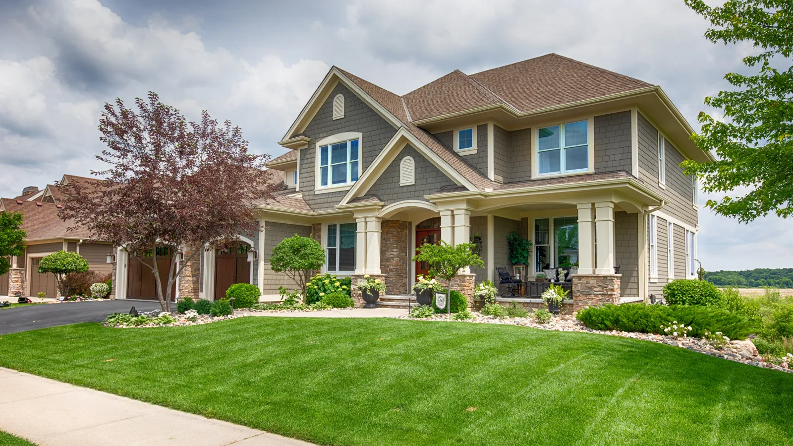 Gray shakes and a brown hip shingle roof on a craftsman style two-story